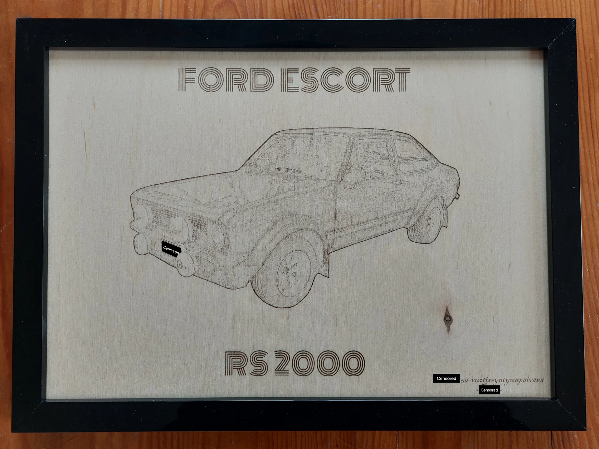 Laserkaiverrettu vaneritaulu, jossa Ford Escort RS 2000, kuva asetettu valokuvakehykseen.